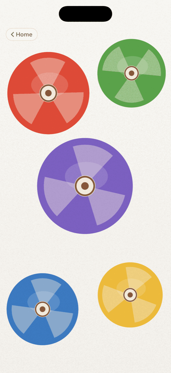Spinning Tops in Twirlio: five big colored discs — red, green, purple, blue and yellow — two of them mid-spin and wobbling.